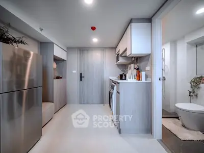 Modern kitchen with sleek appliances and open layout next to a stylish bathroom.