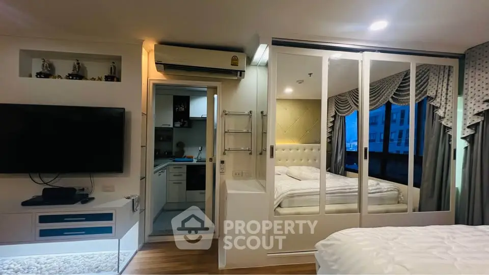 Modern studio apartment with open layout, featuring a cozy bedroom and compact kitchen.