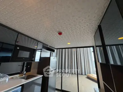 Modern kitchen with sleek appliances and open layout leading to a balcony with floor-to-ceiling windows.