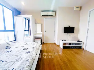 Spacious bedroom with modern decor and large windows for natural light