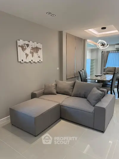 Modern living room with stylish gray sectional sofa and elegant dining area