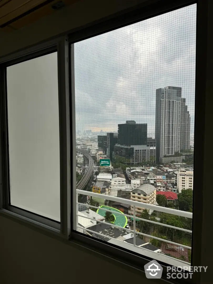 Stunning cityscape view from high-rise apartment window, showcasing urban skyline and modern architecture.