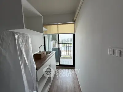 Compact kitchen with balcony view in modern apartment