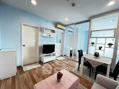 Modern living room with dining area, featuring wooden flooring and stylish decor.