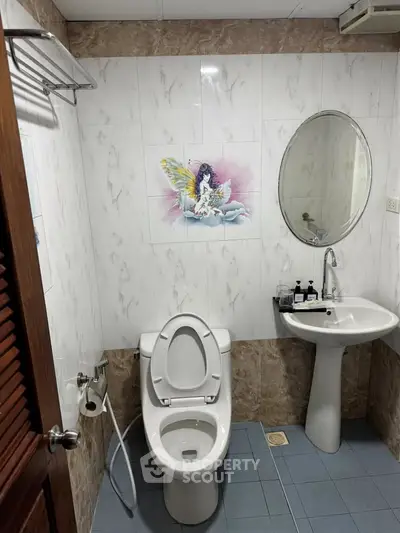 Charming bathroom with elegant fixtures and unique wall art, perfect for a cozy home ambiance.