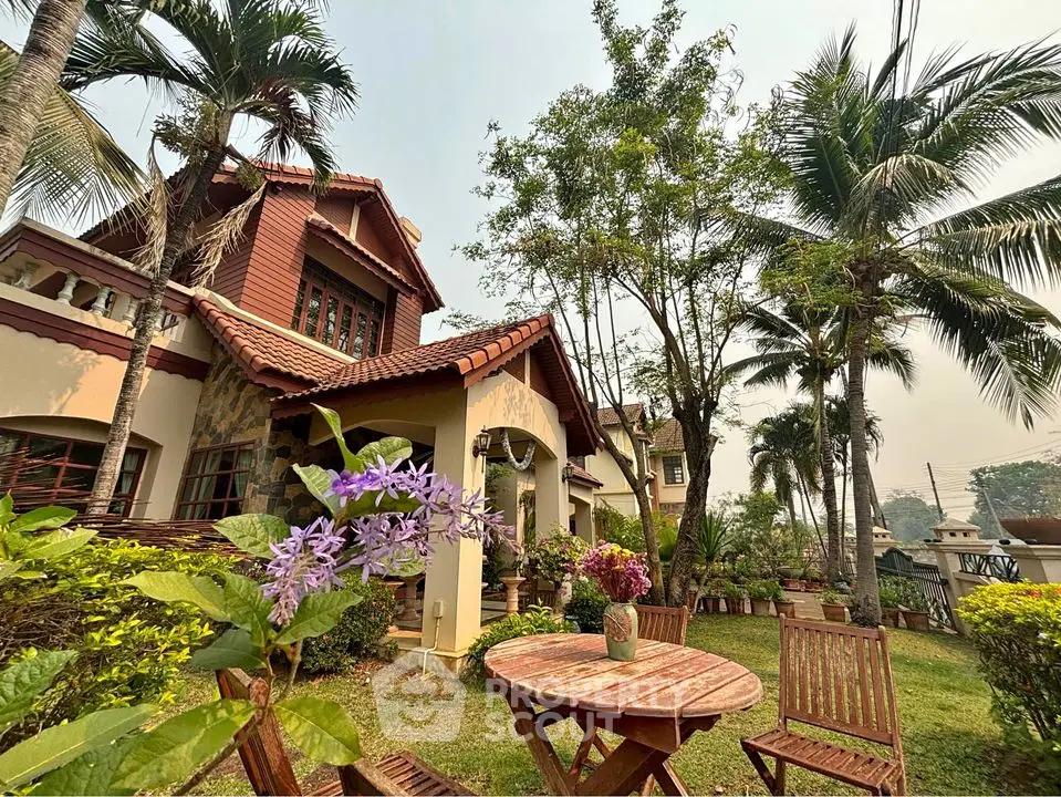 Charming villa with lush garden and outdoor seating, surrounded by tropical palm trees and vibrant flora, showcasing a serene and private living experience.