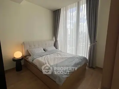 Cozy bedroom with large window and modern decor in a stylish apartment.