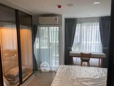 Modern bedroom with large windows, stylish furniture, and natural light.