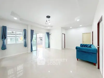 Spacious living room with blue sofa and large windows for natural light