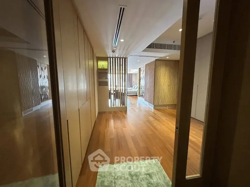 Spacious hallway with wooden flooring leading to a modern living area.