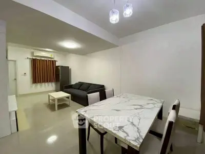 Spacious living room with modern dining area and stylish lighting