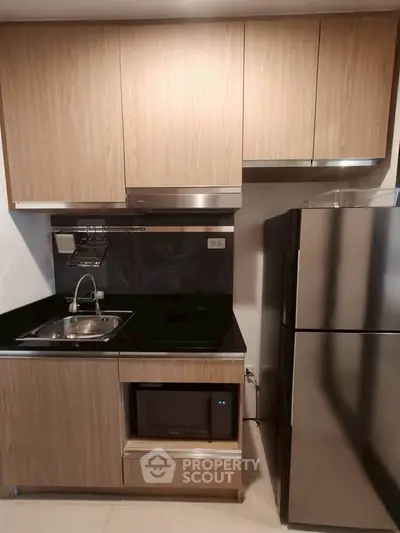 Modern kitchen with sleek cabinetry and stainless steel appliances in a compact layout.