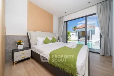 Luxurious bedroom with pool view and modern decor in a stunning real estate property.