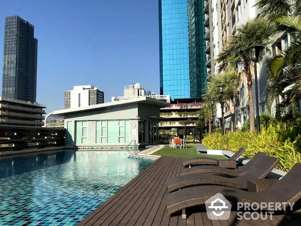 Luxurious rooftop pool with city skyline view and sun loungers in modern high-rise building.