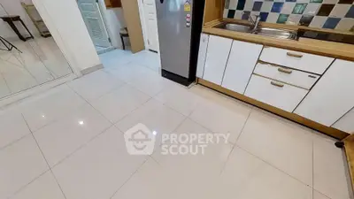 Modern kitchen with sleek white cabinets and stainless steel fridge