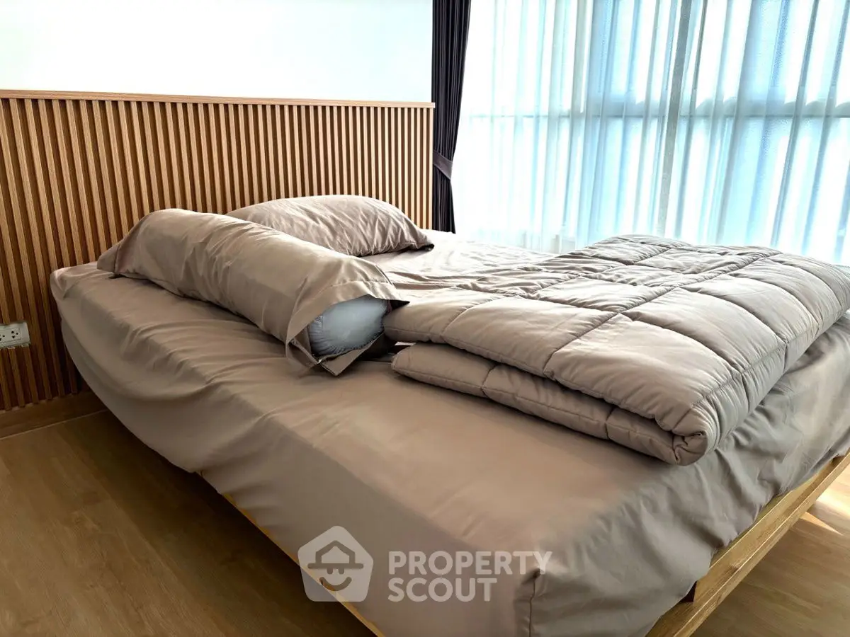 Modern bedroom with stylish wooden headboard and cozy bedding