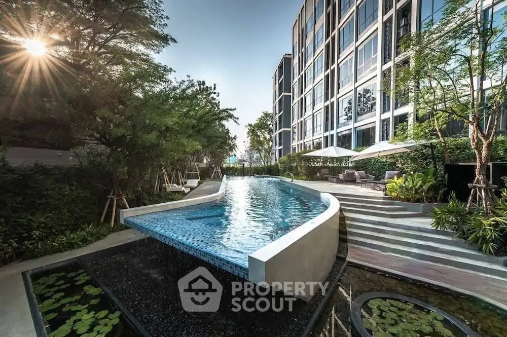 Luxurious modern apartment building with stunning infinity pool and lush greenery.