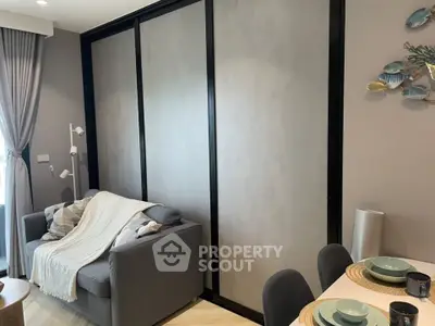 Modern living room with cozy sofa and dining area, featuring stylish decor and natural light.