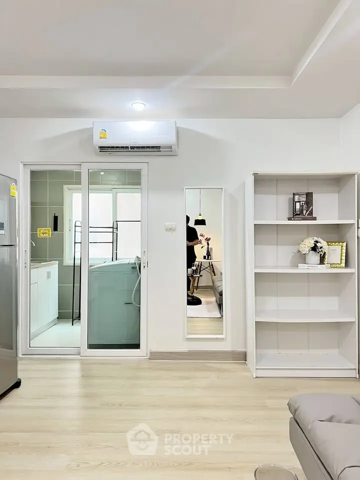Modern living room with sleek design, featuring air conditioning and stylish shelving, perfect for urban living.