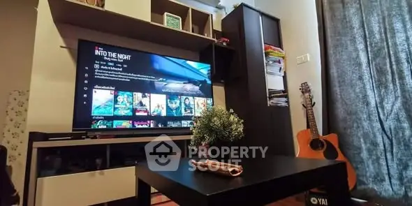 Cozy living room with modern TV setup and guitar decor