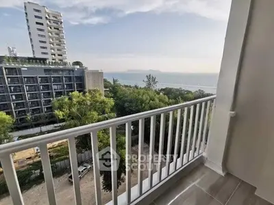 Stunning balcony view overlooking lush greenery and ocean horizon in modern apartment.