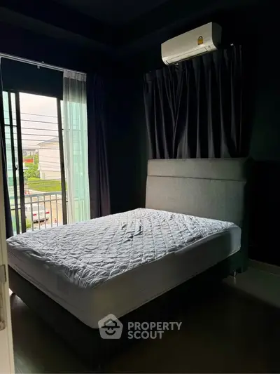 Cozy bedroom with modern air conditioning and natural light from balcony view.