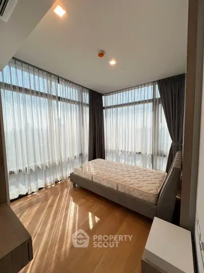 Spacious bedroom with floor-to-ceiling windows and abundant natural light