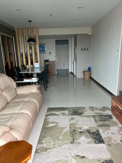 Spacious living room with modern decor and open layout, featuring a comfortable sofa and dining area.