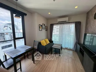 Modern living room with large windows, stylish decor, and natural light in urban apartment.