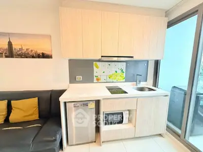 Modern compact kitchen with sleek cabinetry and built-in appliances in a cozy apartment setting.
