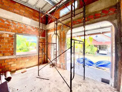 Under-construction property with exposed brick walls and scaffolding, showcasing potential for customization.