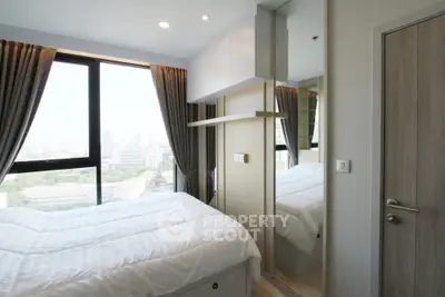 Modern bedroom with large window offering city view, featuring sleek design and ample natural light.