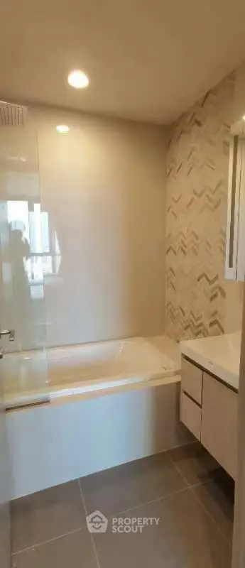 Modern bathroom with stylish tile design and built-in bathtub