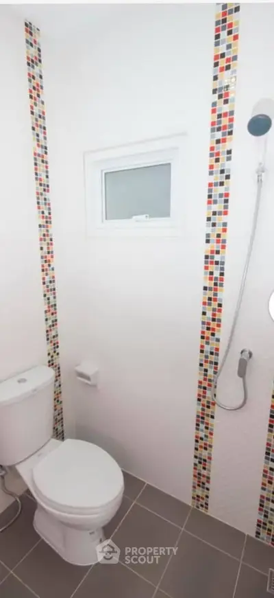 Modern bathroom with colorful mosaic tiles and sleek fixtures.