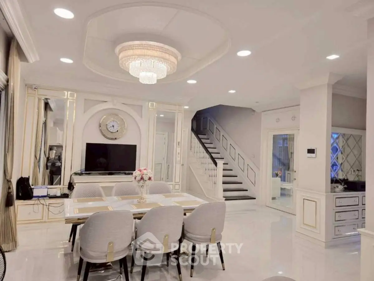 Luxurious open-plan living and dining area with elegant chandelier and modern decor