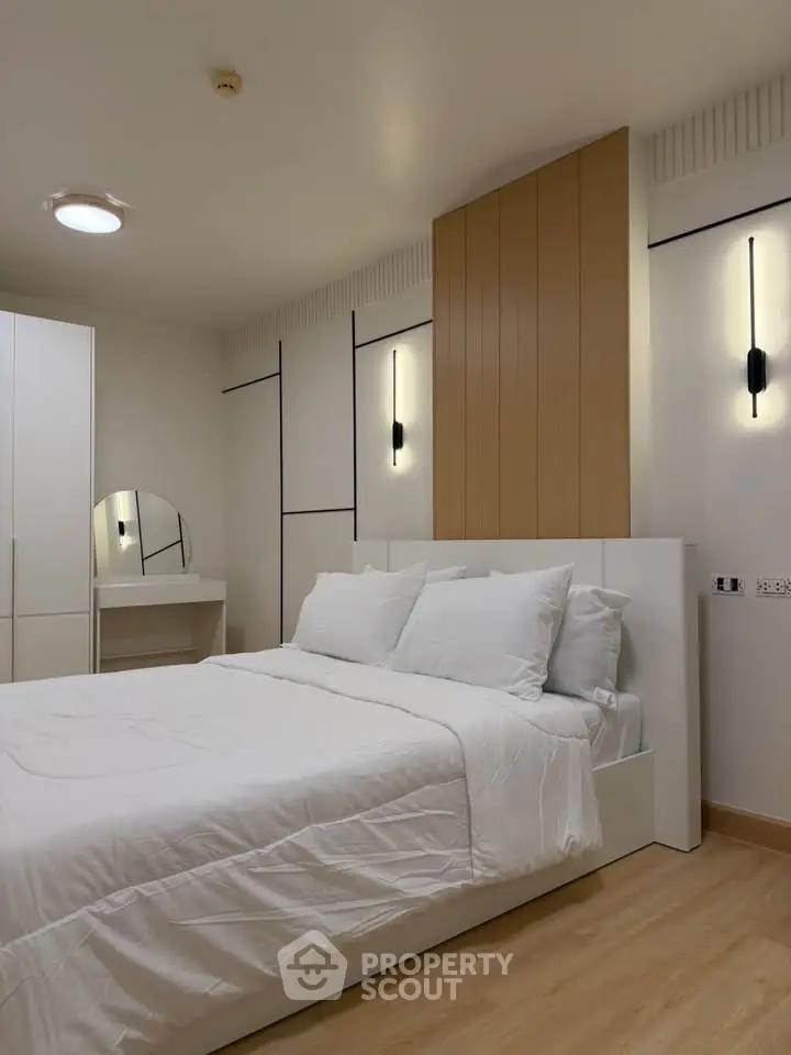 Modern bedroom with sleek design, featuring a cozy bed, stylish lighting, and a minimalist dressing area.