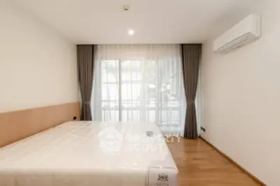 Spacious bedroom with large window and modern air conditioning unit.