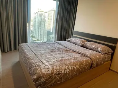 Modern bedroom with city view and stylish bedding in high-rise apartment.
