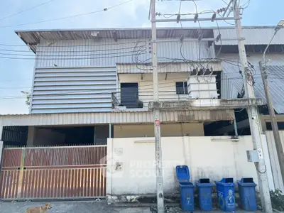 Spacious two-story industrial-style building with gated entrance and utility access.