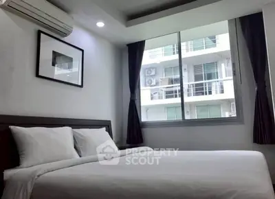 Modern bedroom with large window and air conditioning in urban apartment