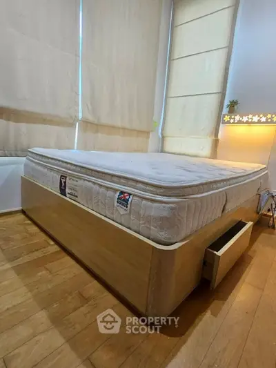Cozy bedroom with wooden flooring and a comfortable bed