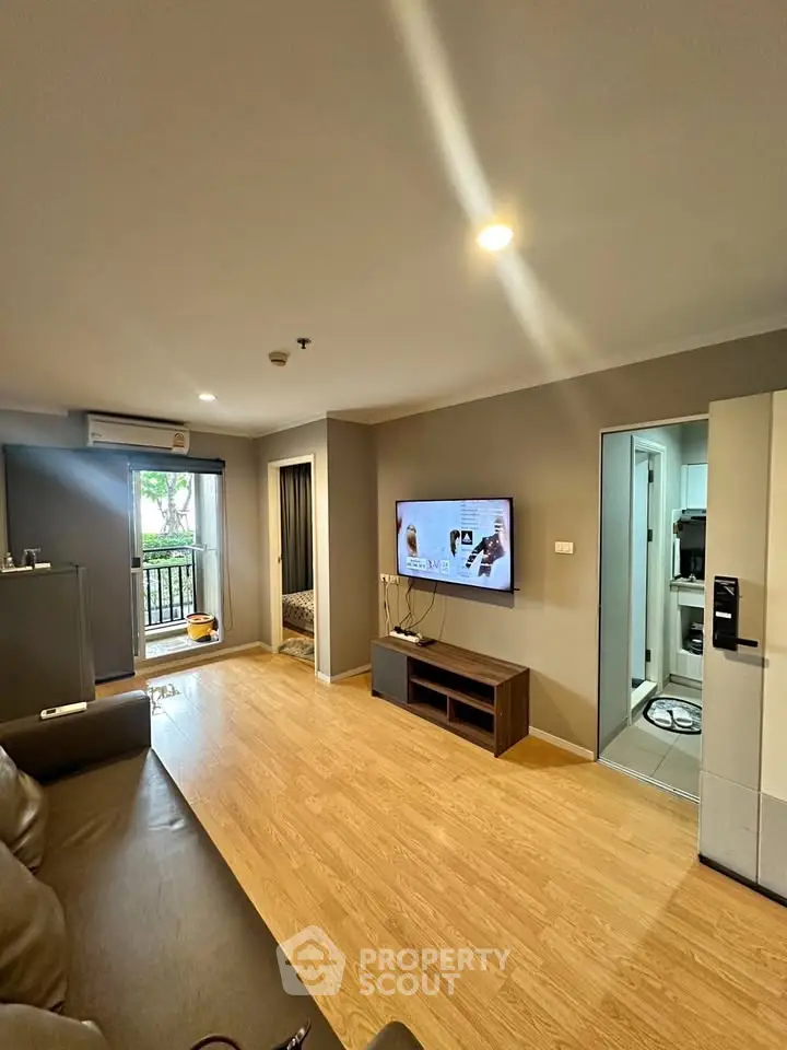 Modern living room with wooden flooring and balcony access in a stylish apartment.