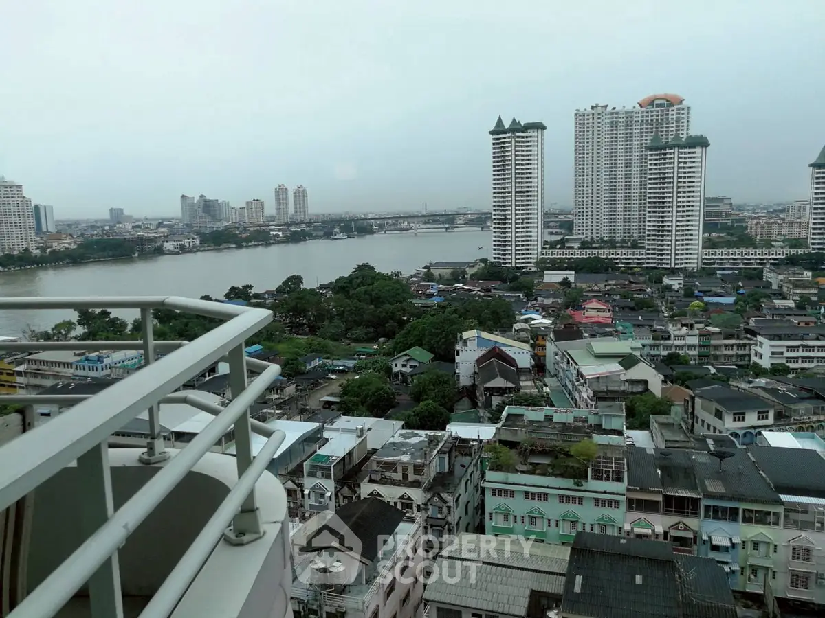 Stunning cityscape view from high-rise balcony overlooking river and skyline.