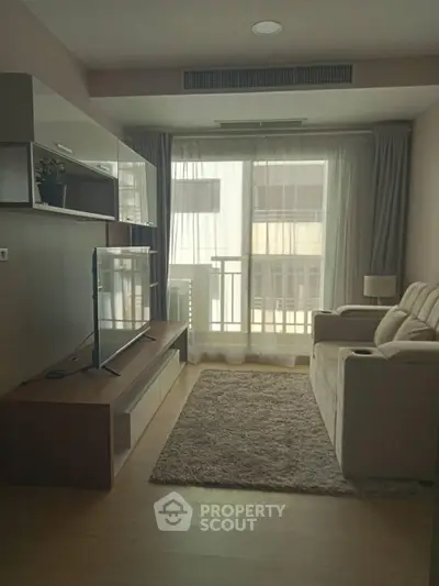 Modern living room with cozy seating and natural light from large window