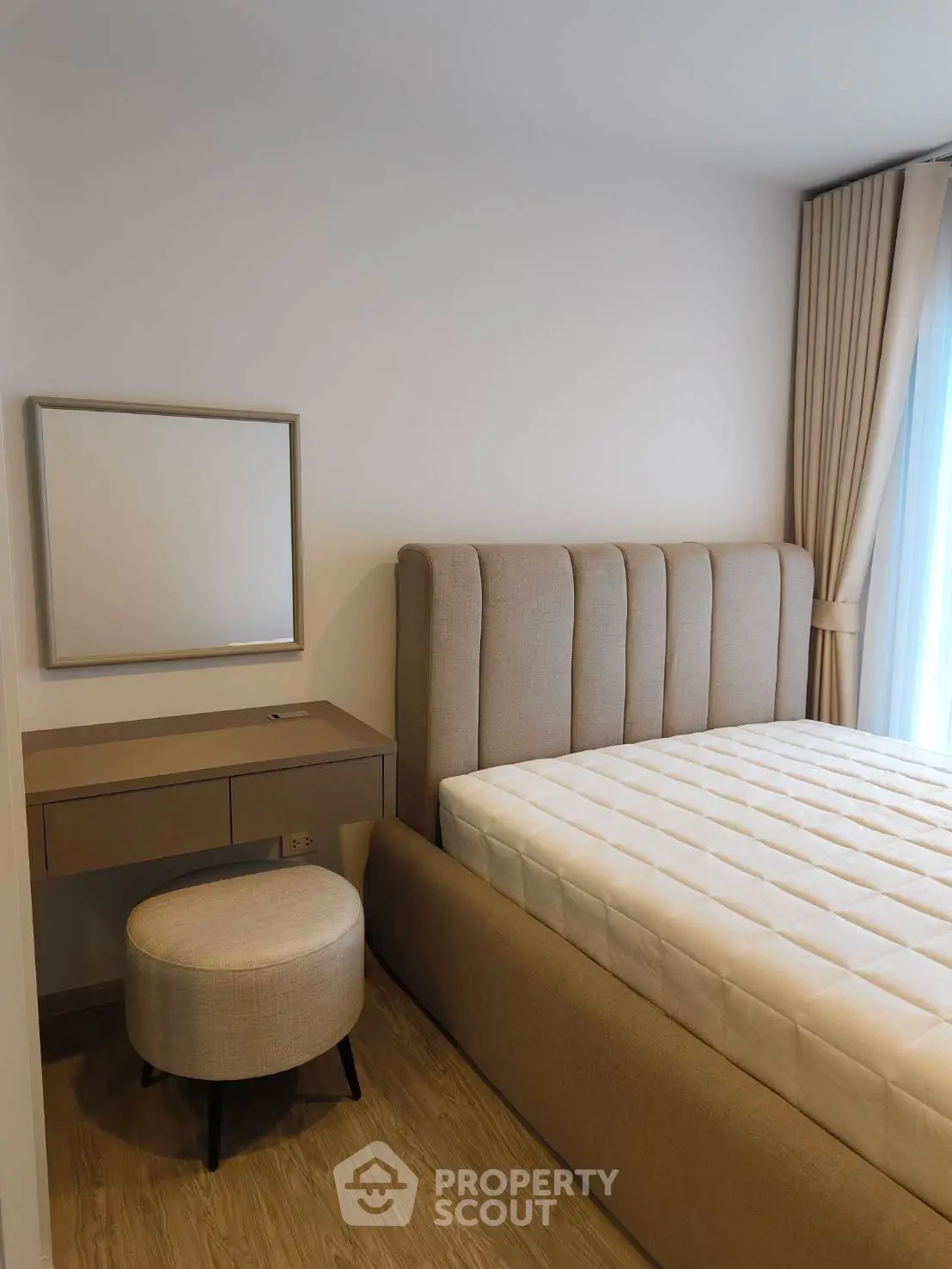 Modern bedroom with elegant bed and stylish vanity in a bright, cozy setting.