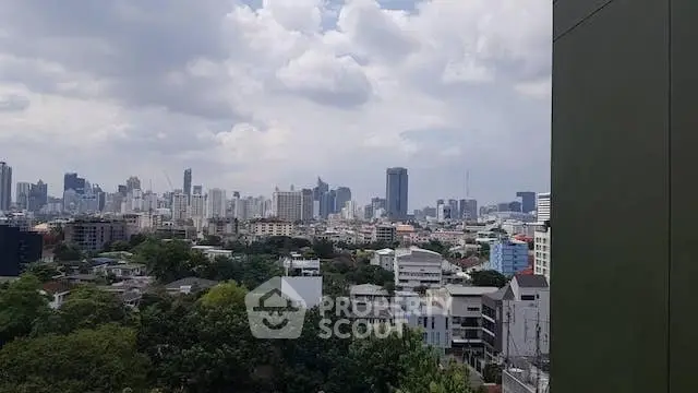 Stunning cityscape view from a high-rise building, showcasing urban skyline and lush greenery.