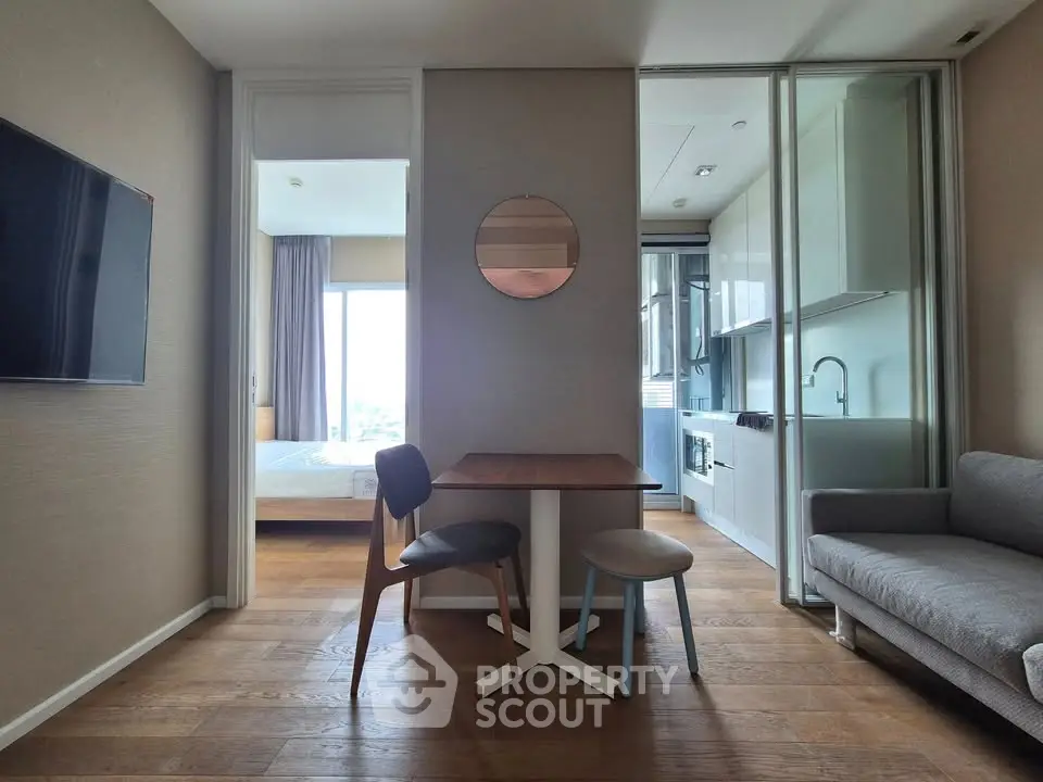 Modern apartment interior with open layout, featuring a cozy living area, dining table, and sleek kitchen.