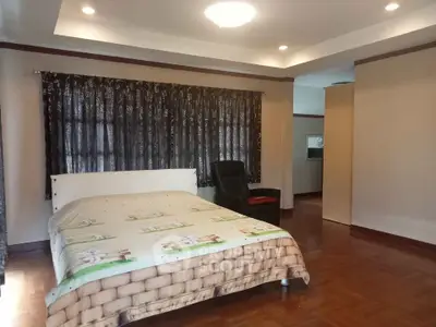 Spacious bedroom with cozy lighting and elegant curtains in a modern home.