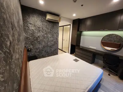 Modern bedroom with stylish stone accent wall and built-in desk, featuring a comfortable mattress and sleek design.