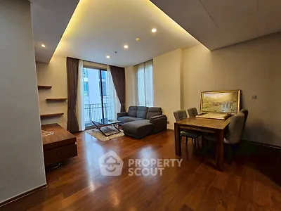 Spacious living room with modern furniture and wooden flooring, featuring a cozy dining area.